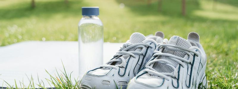 Close-up of comfortable sports shoes and a water bottle